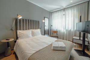 una camera da letto con un letto grande e una TV a schermo piatto di River Eyes Suites a Vila Nova de Gaia Altre 73 foto