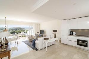 uma sala de estar branca com um sofá branco e uma mesa em Casa Aloha I by Roomservices em Marbella