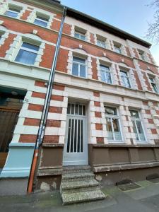 a red brick building with a white door and stairs at Cil Apt.- Gemütliche Wohnung am Philosophenweg mit Netflix in zentraler & ruhiger Lage in Kassel