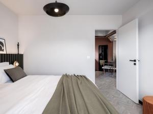 a bedroom with a bed and a hallway with a table at TESSERA Urban Chania in Chania