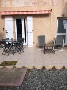 a patio with a table and chairs and a building at BERNARDINI Emplacement exceptionnel in Sari Solenzara