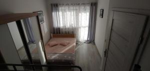 Habitación pequeña con cama y ventana en Helenka, en Debina