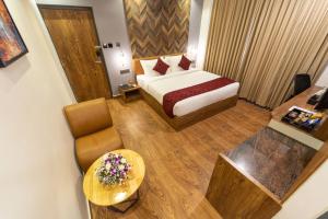 a small hotel room with a bed and a table at Clarks Inn , Airport Bangalore in Yelahanka