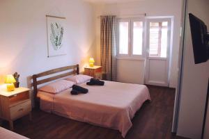 ein Schlafzimmer mit einem Bett mit zwei schwarzen Schuhen darauf in der Unterkunft Apartment VistaMare Croatia in Luka