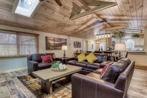 a living room with leather furniture and a table at Whispering Winds in Gatlinburg