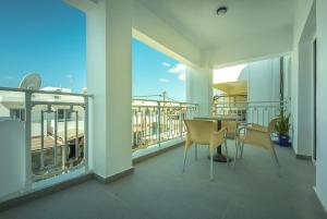 a balcony with a table and chairs on it at Sophies Greek Gateway in Kardamaina