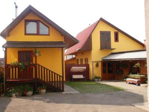 a yellow house with a porch and a balcony at Chata u Jozefa in Hrabušice