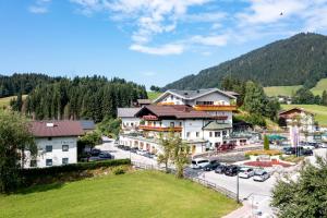 a town in the mountains with cars parked in a parking lot at Familienhotel Felsenhof in Flachau