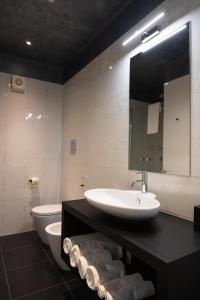 a bathroom with two sinks and a toilet and a mirror at Casabianca Resort in Fondi