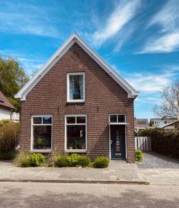 a red brick house with a window at Vrijstaande gezinswoning met ruime tuin in Zwolle