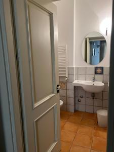 a bathroom with a toilet and a sink and a door at La foresteria in Agrigento