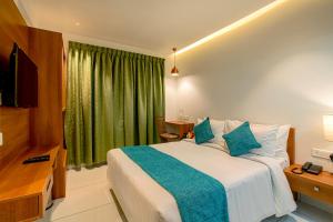 - une chambre avec un grand lit et un rideau vert dans l'établissement Harivaram Yuga, à Guruvāyūr 45 autres photos