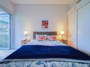 a bedroom with a large bed with two lamps at Glebe House Homestay in Sydney