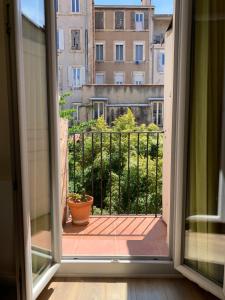 ein offenes Fenster mit Blick auf einen Balkon in der Unterkunft Marseille LOFT 50m2 au cœur du Cours Julien in Marseille