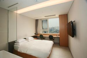 a hotel room with a bed and a window at Hotel The Designers Hongdae in Seoul