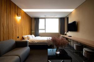a hotel room with a bed and a couch at Hotel The Designers Hongdae in Seoul