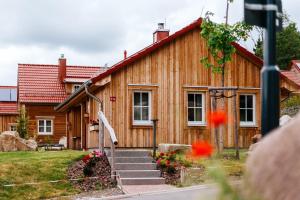 a wooden house with stairs in front of it at Das Schierke Harzresort in Schierke