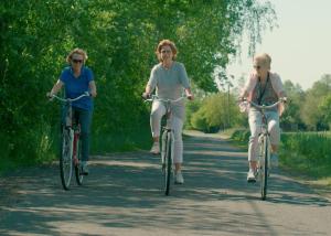 three people riding bikes down a dirt road at Ferienhaus Spreewald direkt am Wasser in Burg Kauper