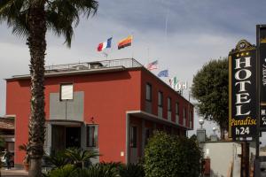 a red building with flags on top of it at Hotel Paradiso in Lago Patria