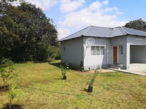 a house with a garden in front of it at Sheila's Cottage in Lusaka
