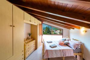 mała sypialnia z łóżkiem i oknem w obiekcie Tresa Bay House - Lugano Lake w mieście Lavena Ponte Tresa