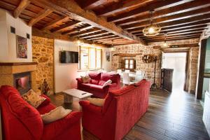 a living room with red furniture and a stone wall at Los Campos Vivienda Vacacional in Cangas de Onís