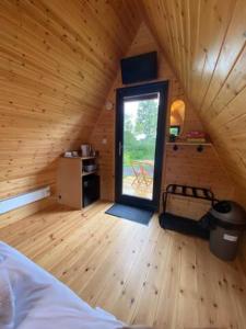 um quarto com uma cama e uma janela num camarote em Countryside Cabin em Taunton