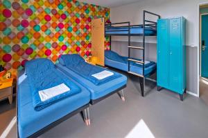 a room with two bunk beds and a colorful wall at Stayokay Hostel Den Haag in The Hague