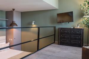 una camera con letto, TV e cassettiera di Olive Nature – Tourism Apartments a Porto
