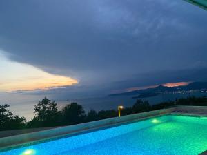 a swimming pool with a sunset in the background at Villa Horus in Sveti Stefan