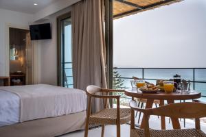 a hotel room with a bed and a table with food on it at Lorraine's Boutique Suites in Lourdata