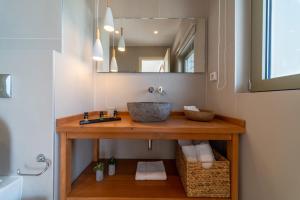a bathroom with a sink and a mirror at Lorraine's Boutique Suites in Lourdata
