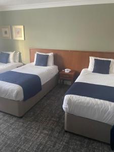 a hotel room with two beds and two night stands at Caledonian Hotel in Newcastle upon Tyne