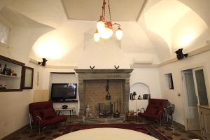 a living room with a fireplace and a tv at Historic house by the lake La Renée Casa Vacanza in Predore