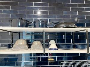 a kitchen shelf with pots and pans and plates at 99Stay Sasebo SGx in Sasebo