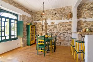 a dining room with a green table and chairs at Algarve Charming Rural 1br Villa in Santa Bárbara de Nexe