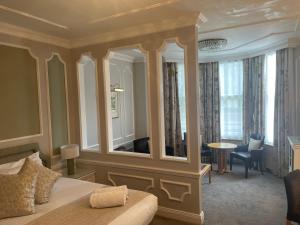 a bedroom with a bed and a large mirror at Caledonian Hotel in Newcastle upon Tyne