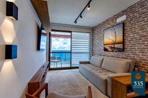 a living room with a couch and a brick wall at BARRA Vista Mar Lindo apartamento, Wi-Fi 300Mbps in Salvador