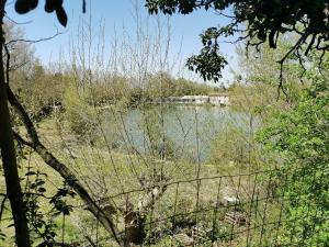 a view of a lake with a house in the distance at GITE COTE LAC in Valréas