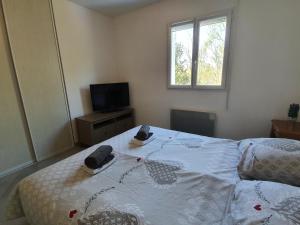 a bedroom with a bed with two phones on it at GITE COTE LAC in Valréas +2 photos