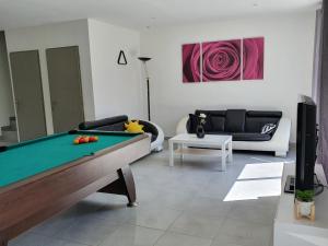 a living room with a pool table and a couch at GITE COTE LAC in Valréas