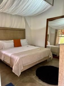 um quarto com uma cama grande e um espelho em Pousada Estancia Canastra em Delfinópolis