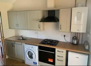 Il comprend une cuisine équipée d'une cuisinière. four supérieur à côté d'un évier dans l'établissement Salcombe Holiday Cottage, à Wilpshire