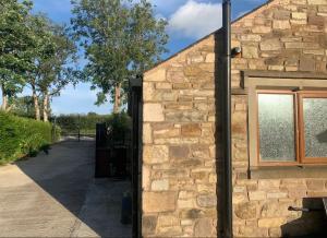 a stone building with a window on the side of it at Salcombe Holiday Cottage in Wilpshire