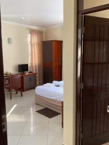 1 dormitorio con 1 cama y escritorio con ordenador en Pensao Marhaba Residencial en Maputo