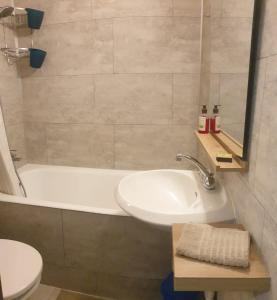 Un baño con lavabo, bañera e inodoro. en FACE MER ENTRE PLAGE ET MARINA, en Bormes-les-Mimosas