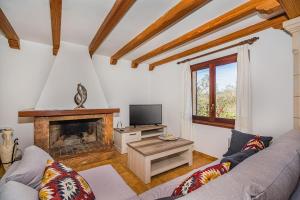 a living room with a couch and a fireplace at Magdalena in Pollença