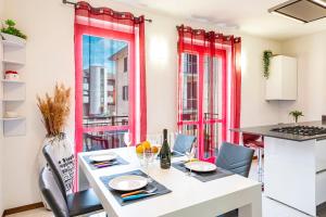 une cuisine avec des fenêtres rouges et une table avec des chaises dans l'établissement Tresa Bay House - Lugano Lake, à Lavena Ponte Tresa