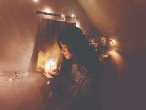 een vrouw staat in een kamer met licht bij MŨM HOMESTAY MỘC CHÂU in Mộc Châu