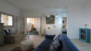 a living room with a blue couch and a bathroom at Grecalotto Apartment in La Maddalena